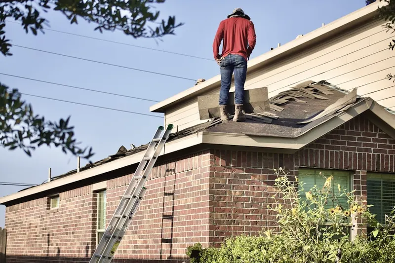 Professional roofer working on a residential roof in Westbrook Village